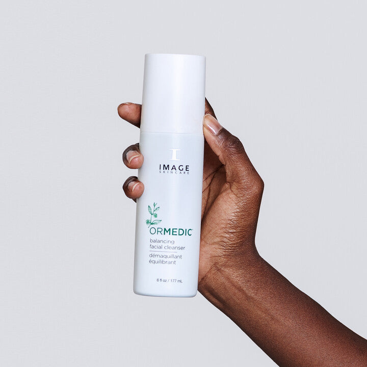 Model holding ORMEDIC Balancing Facial Cleanser