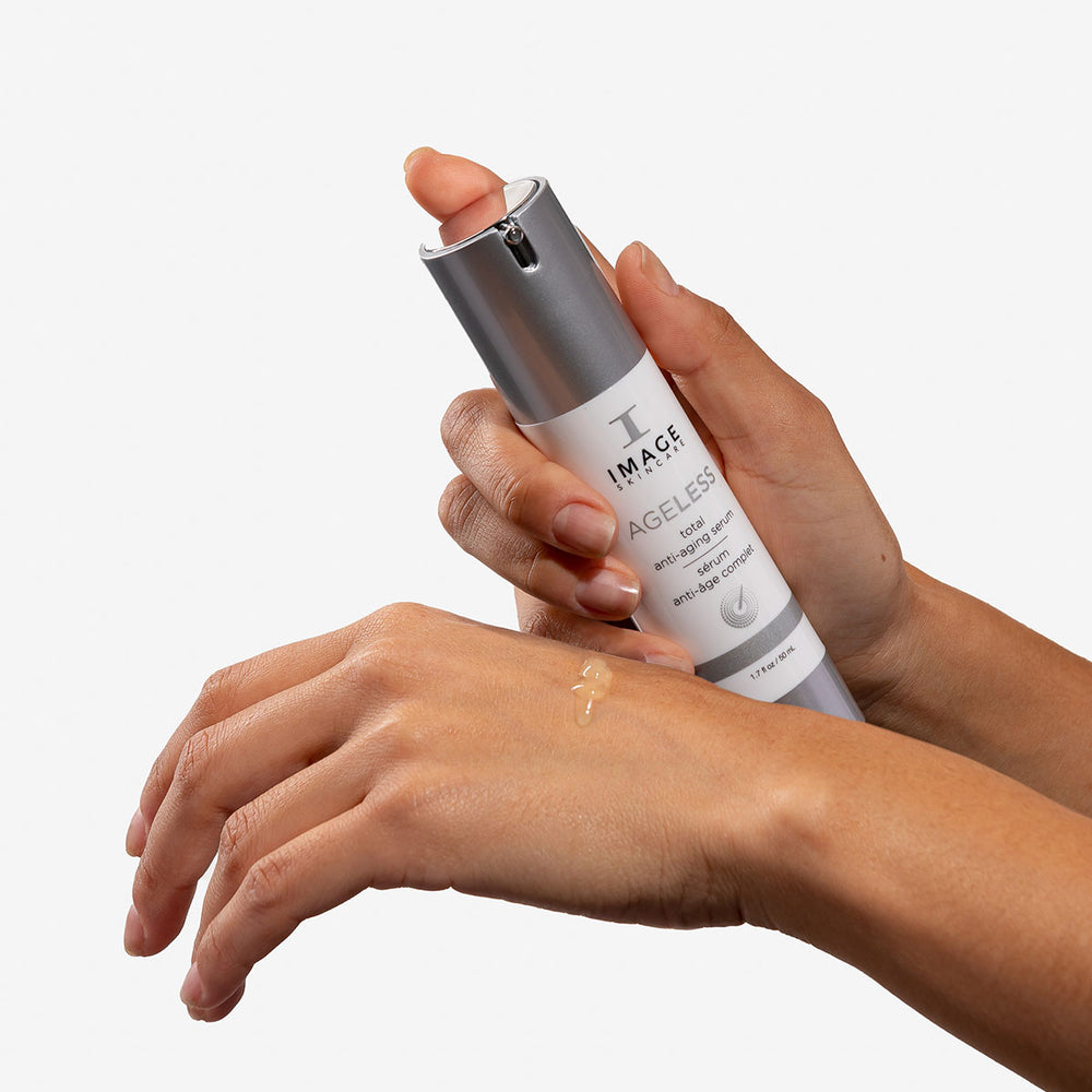 Model applying AGELESS Total Anti-Aging Serum on hand