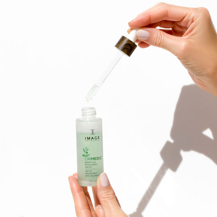 Model holding ORMEDIC Balancing Antioxidant Serum bottle