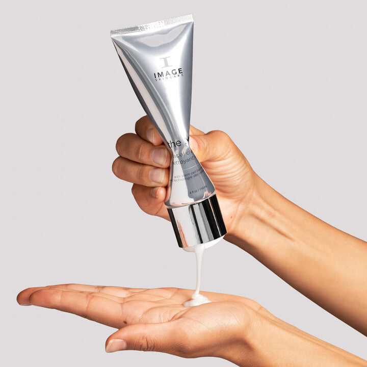 Model squeezing The MAX Facial Cleanser onto hand