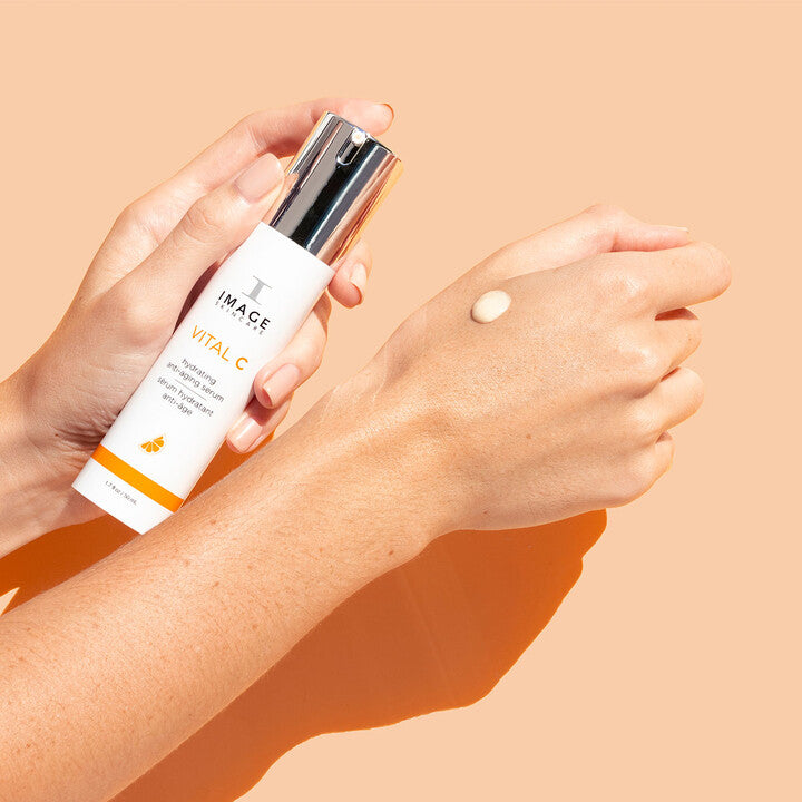 Model pumping VITAL C Hydrating Anti-Aging Serum on to hand