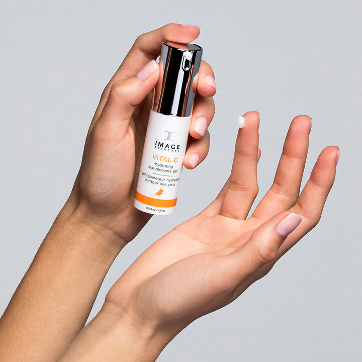 Model squeezing VITAL C Hydrating Eye Recovery Gel on to finger