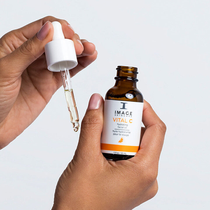 Model applying VITAL C Hydrating Facial Oil on to hand