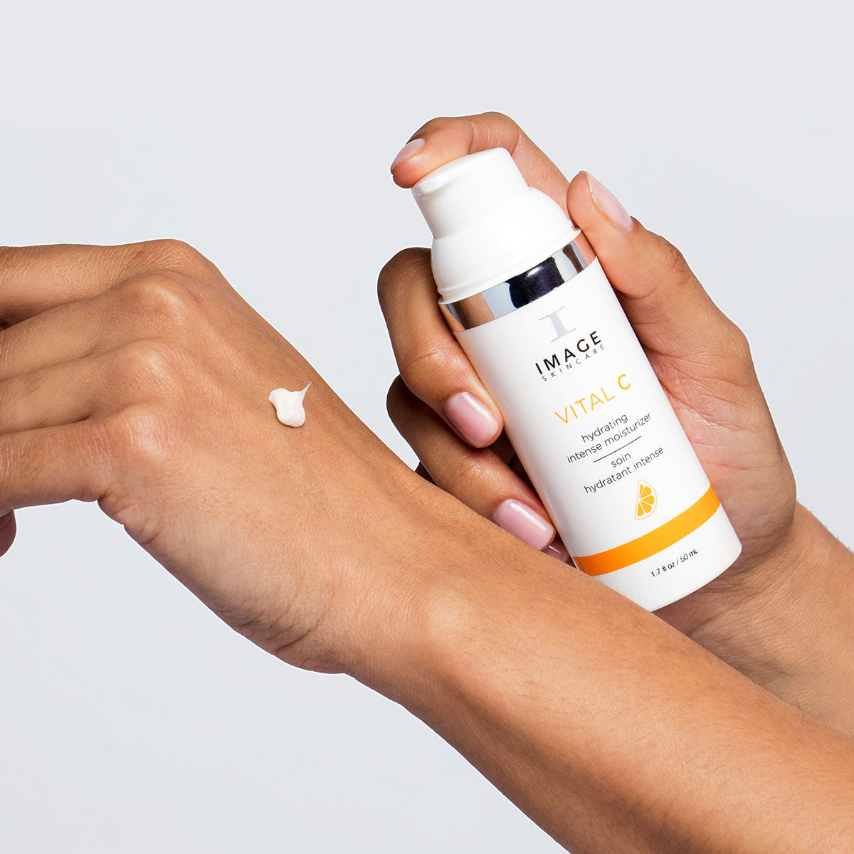 Model pumping VITAL C Hydrating Intense Moisturizer on to hand